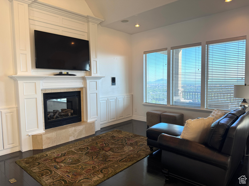 Living room featuring a tiled fireplace, recessed lighting, vaulted ceiling, and dark wood-style floors