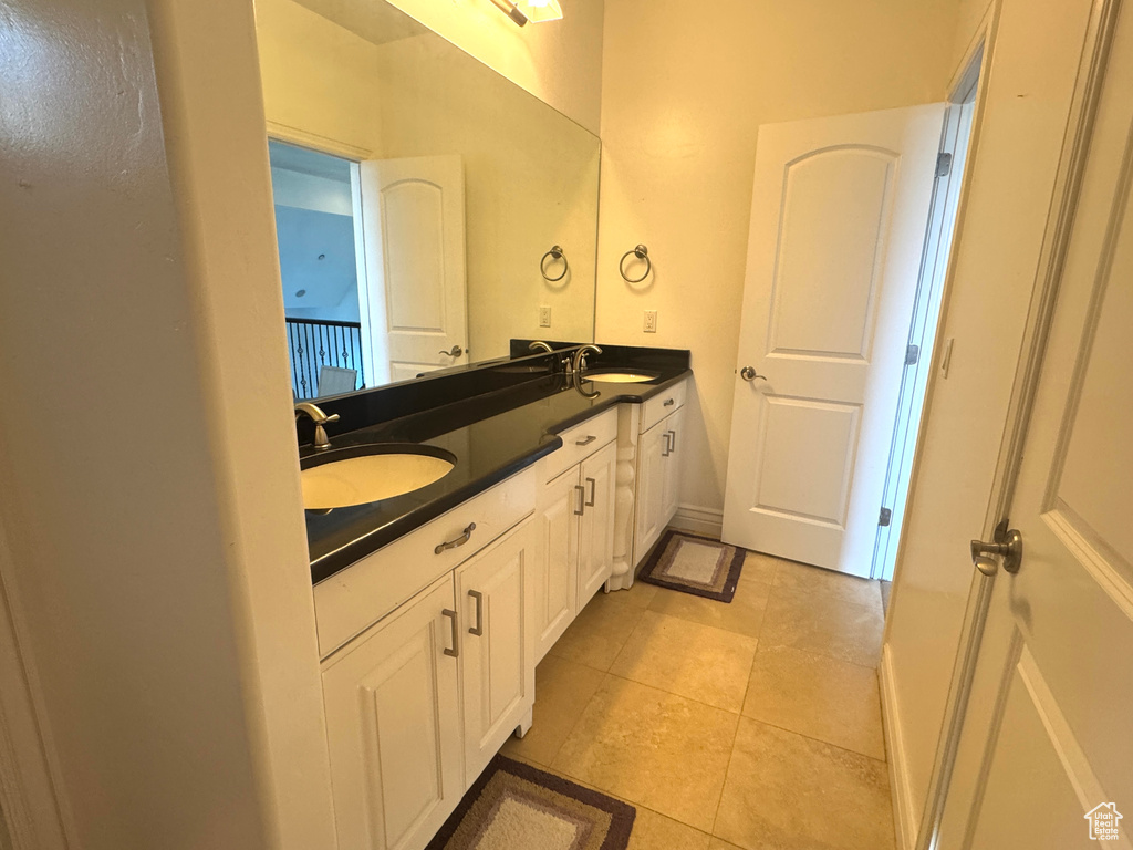 Bathroom with double vanity and tile patterned flooring