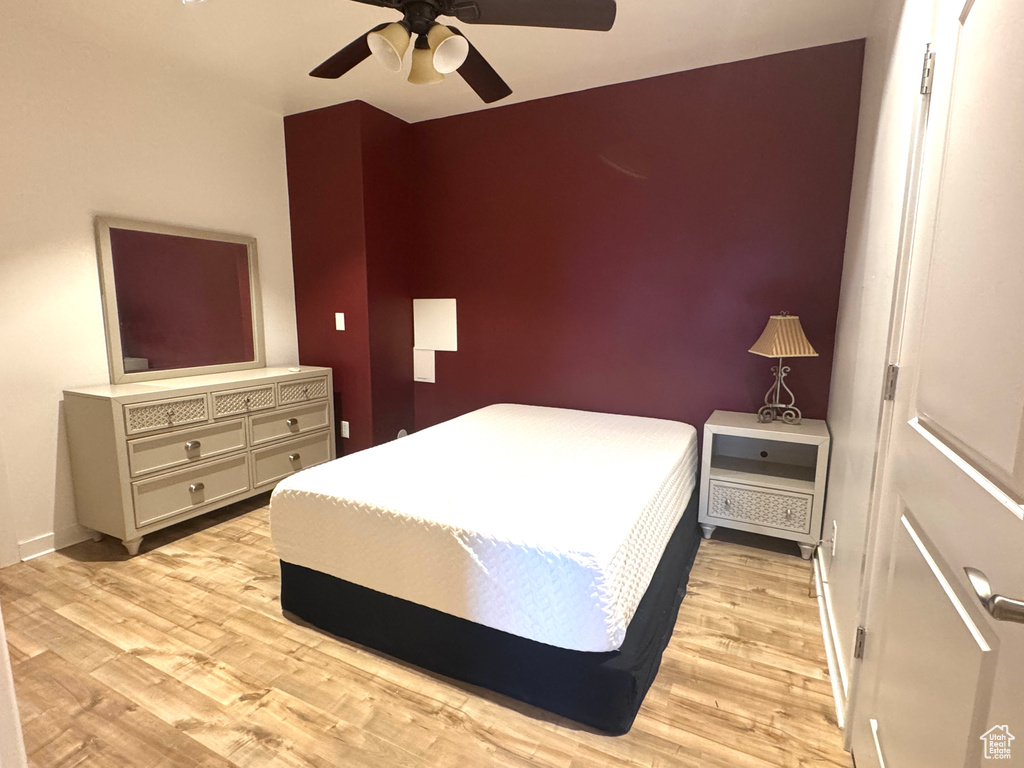 Bedroom with light wood-type flooring, baseboards, and a ceiling fan
