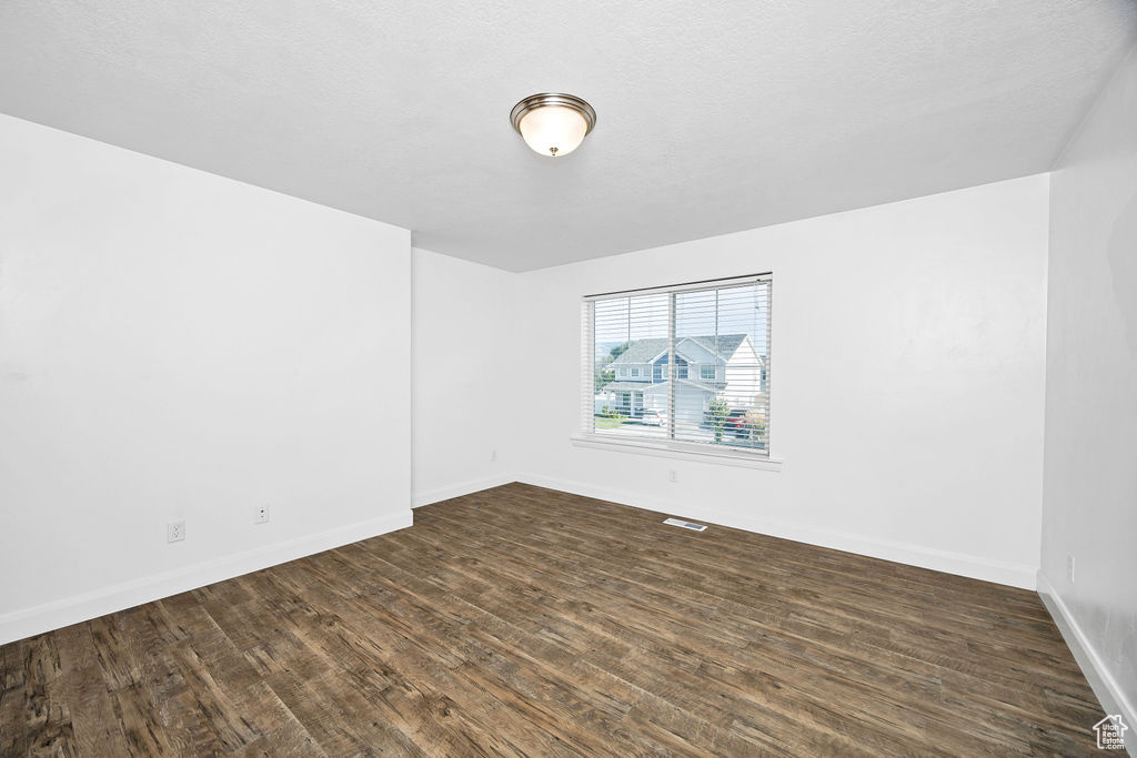 Unfurnished room with dark wood-style floors and baseboards