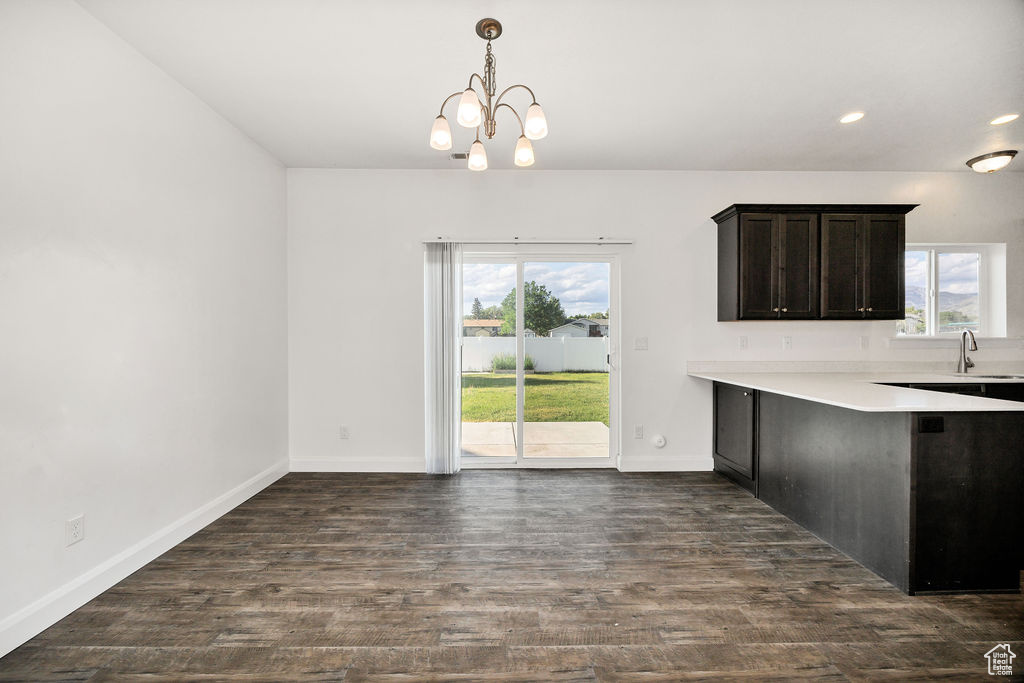 Kitchen featuring plenty of natural light, light countertops, dark wood-type flooring, a chandelier, and recessed lighting