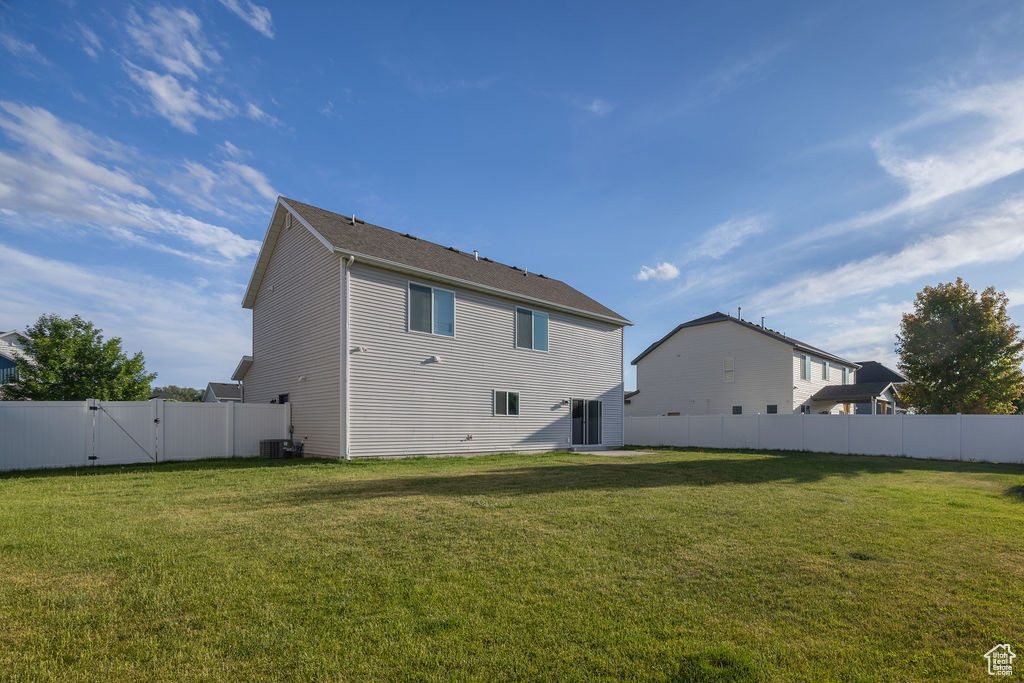Back of property with a gate and central air condition unit