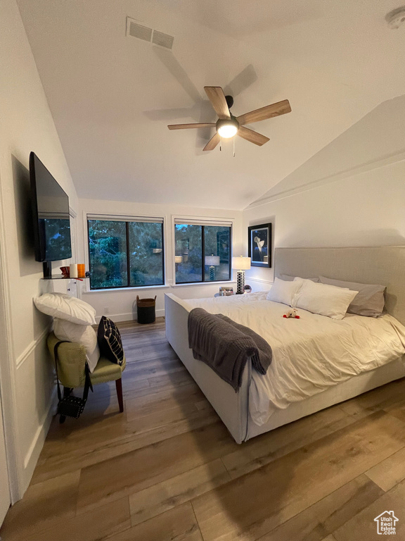 Bedroom with lofted ceiling, wood finished floors, and a ceiling fan