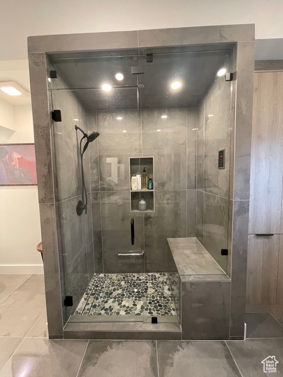Bathroom with a stall shower, baseboards, and tile patterned flooring