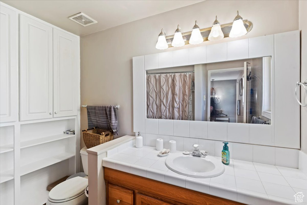 Bathroom with vanity, toilet, and a shower with shower curtain