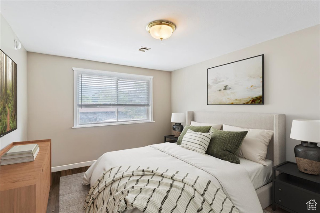 Bedroom with wood finished floors and baseboards