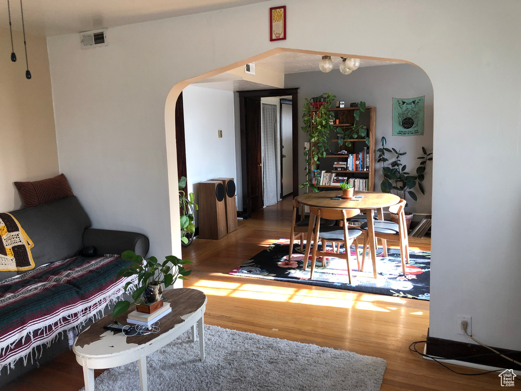 Living area featuring arched walkways and wood finished floors