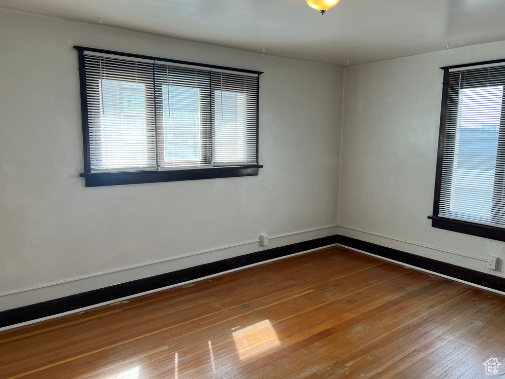 Empty room with hardwood / wood-style flooring and baseboards