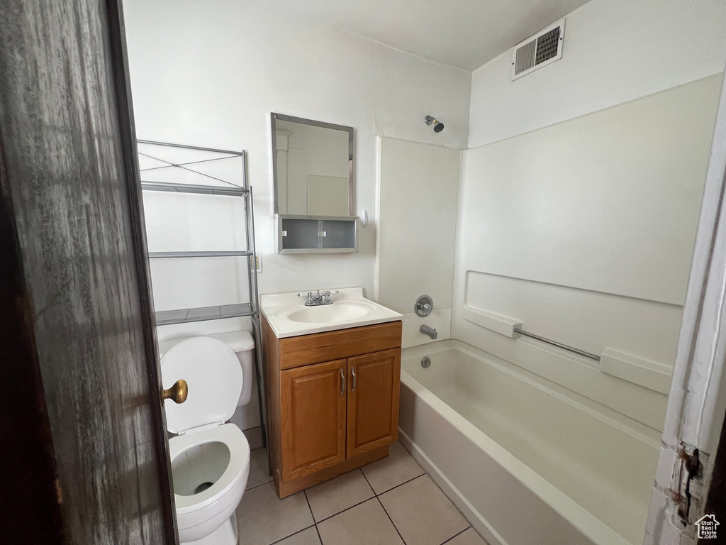 Bathroom featuring toilet, tile patterned floors, vanity, and shower / tub combination