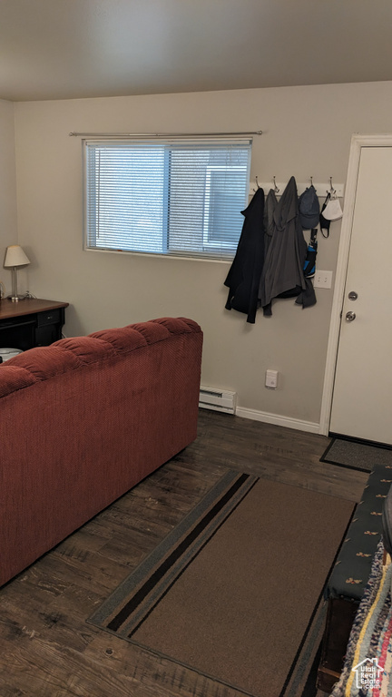 Living area with baseboard heating, wood finished floors, and baseboards