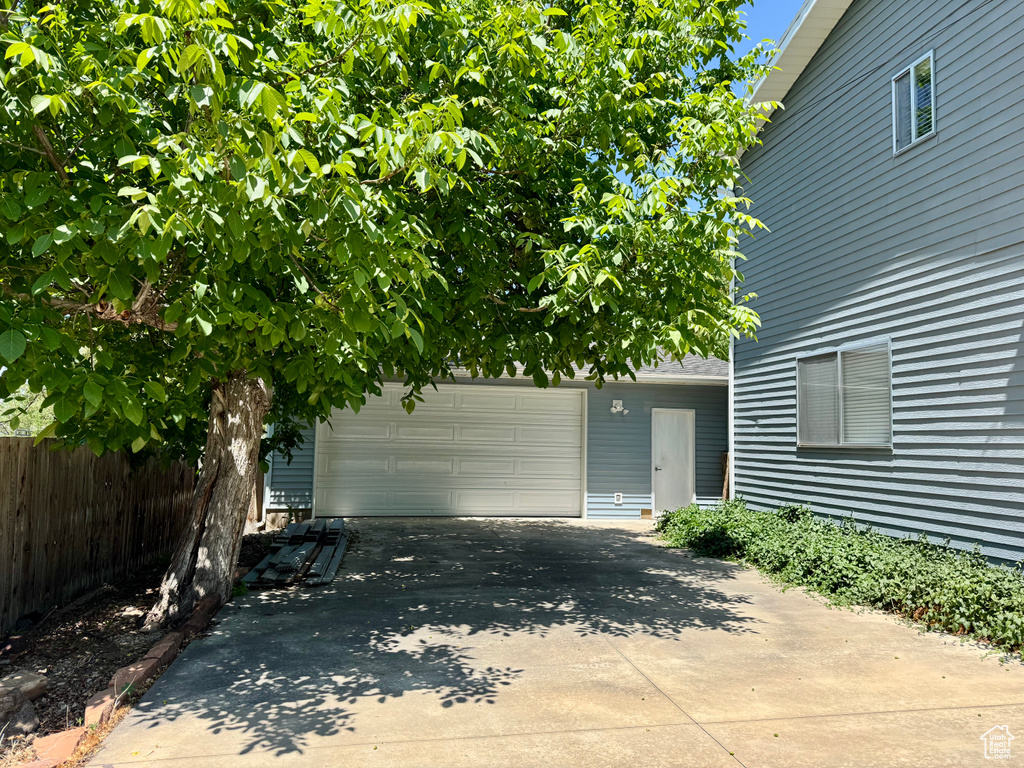 Doorway to property with a garage and concrete driveway