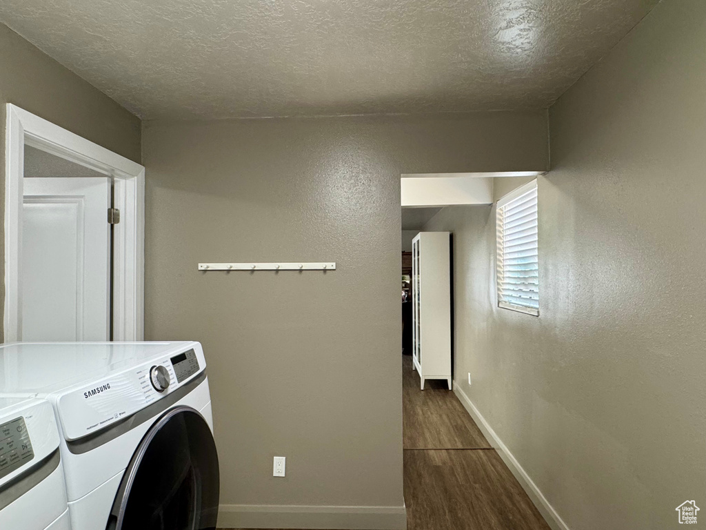 Laundry room with independent washer and dryer, dark wood-style floors, baseboards, and a textured ceiling