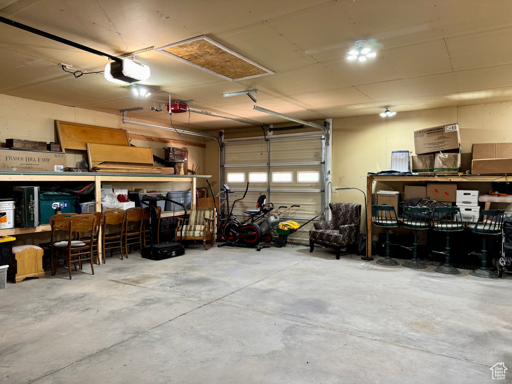 Garage featuring a garage door opener and a workshop area