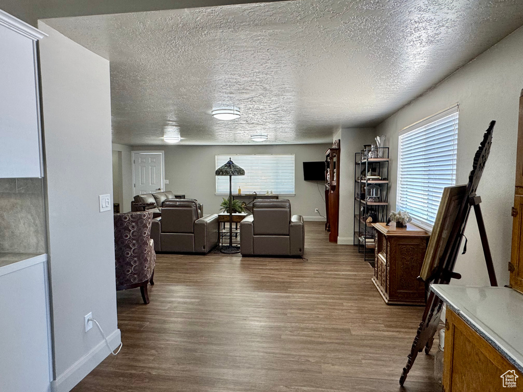 Living room with wood finished floors, baseboards, and a textured ceiling