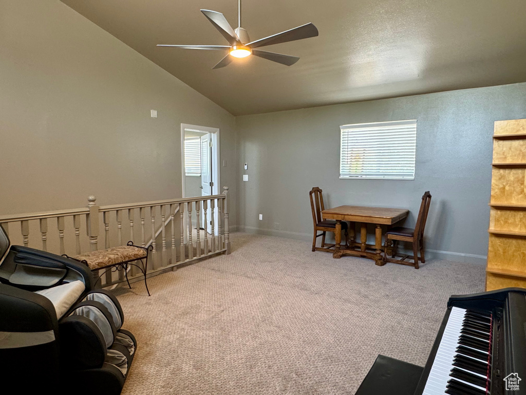 Dining space with ceiling fan, carpet, lofted ceiling, and baseboards