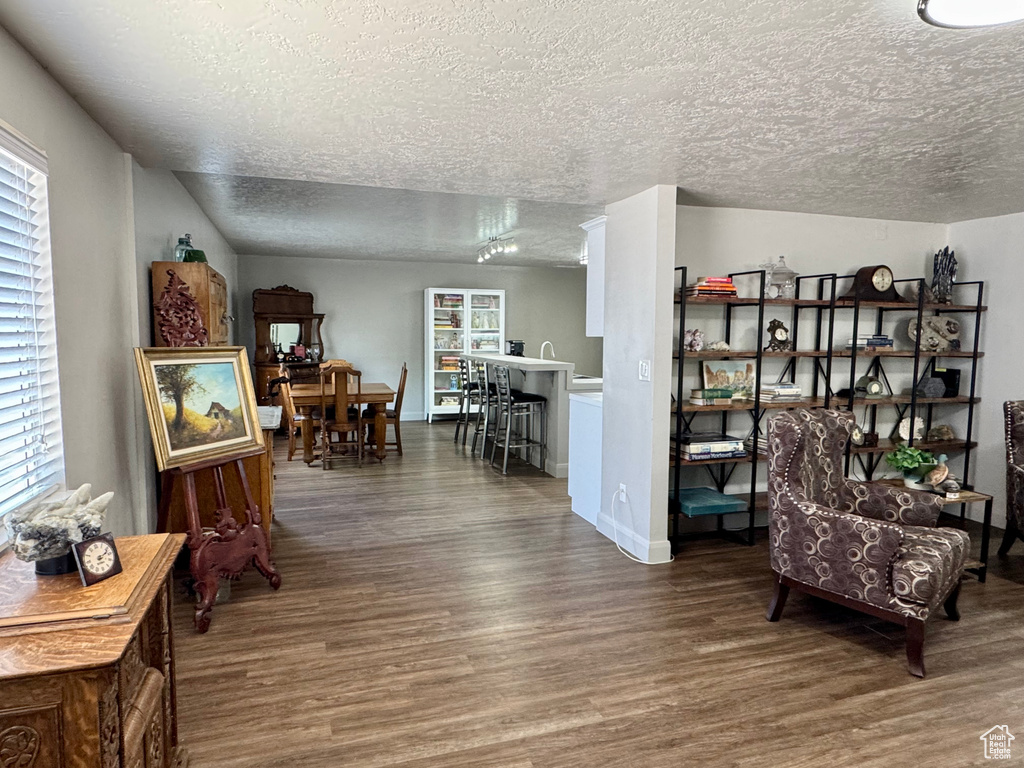 Sitting room with wood finished floors, a textured ceiling, and healthy amount of natural light