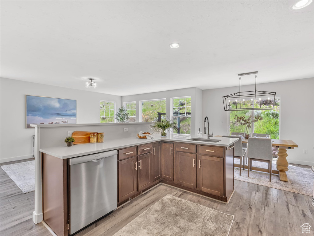 Kitchen featuring dishwasher, a sink, healthy amount of natural light, light wood finished floors, and recessed lighting