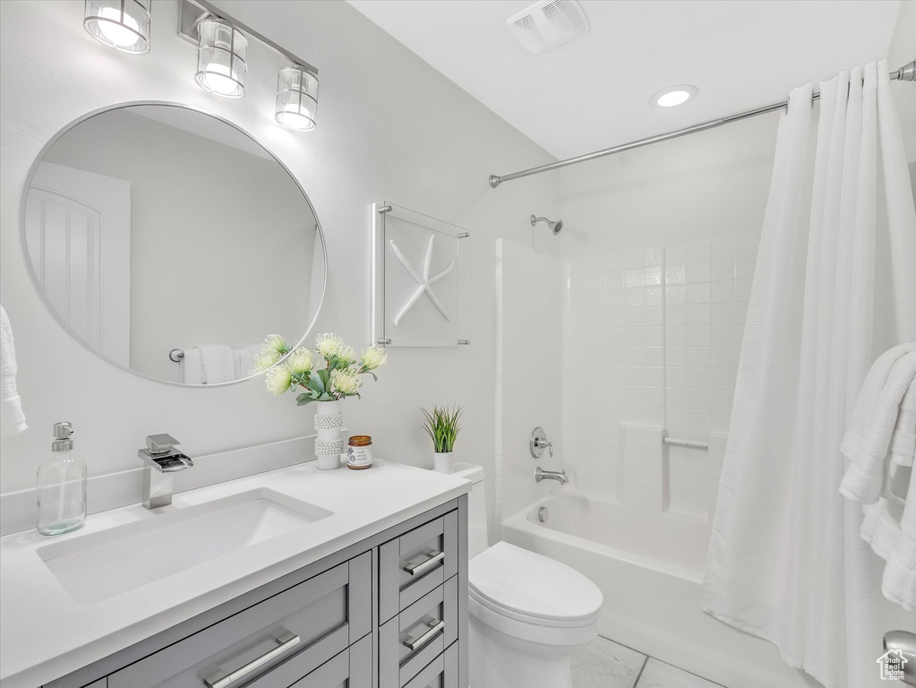 Bathroom with vanity, shower / tub combo, toilet, and tile patterned floors