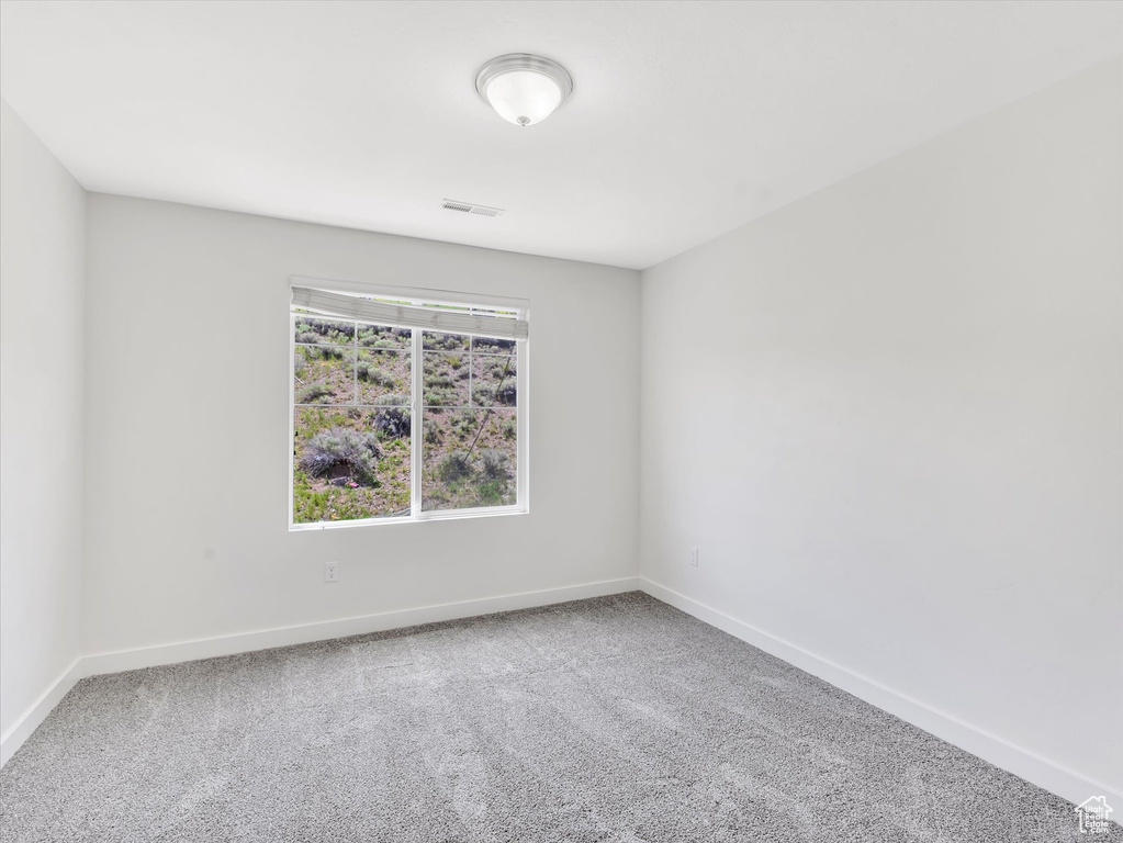 Carpeted empty room with baseboards