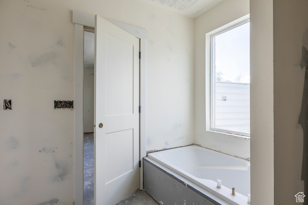 Full bath featuring healthy amount of natural light and a bath