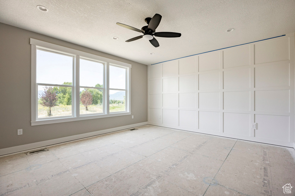 Spare room with a textured ceiling, a ceiling fan, and recessed lighting