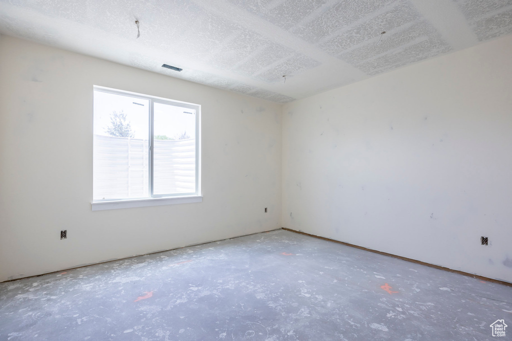 Empty room featuring concrete floors and a textured ceiling