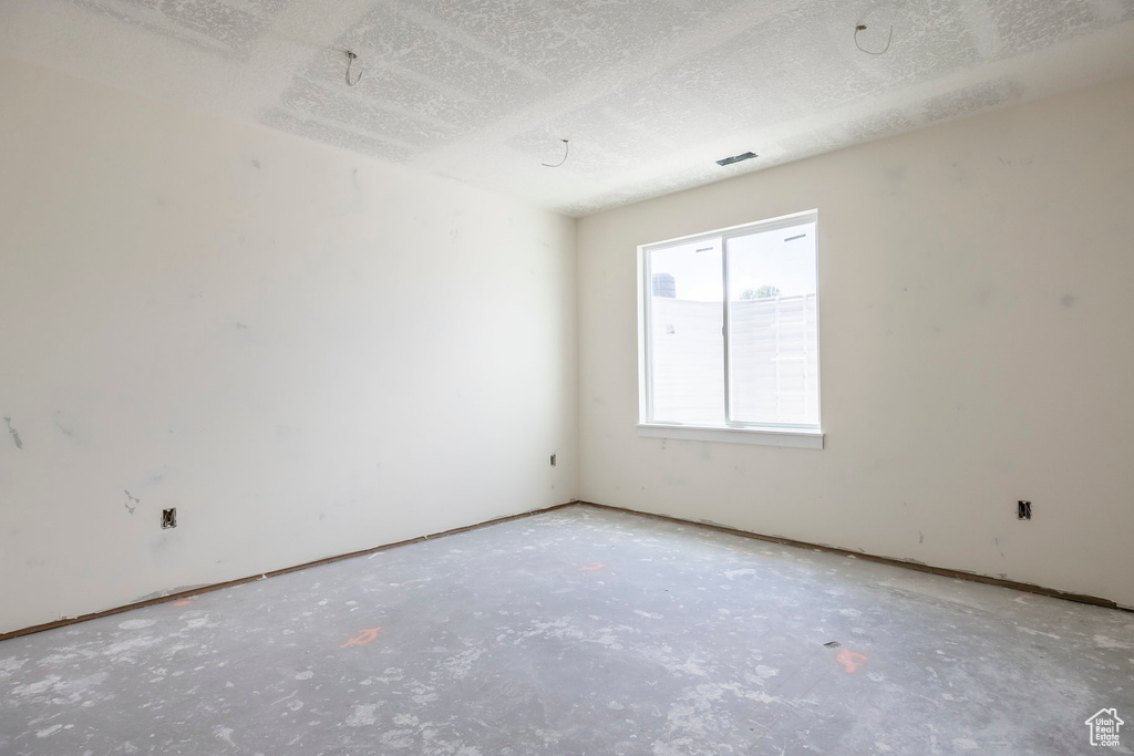 Unfurnished room featuring a textured ceiling