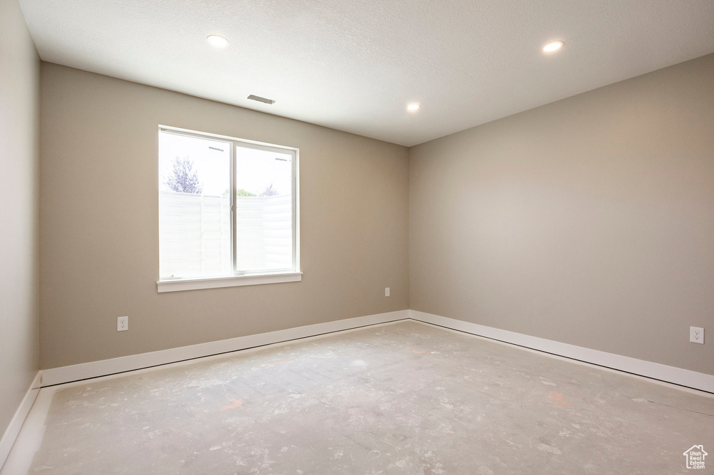 Empty room featuring recessed lighting and concrete flooring