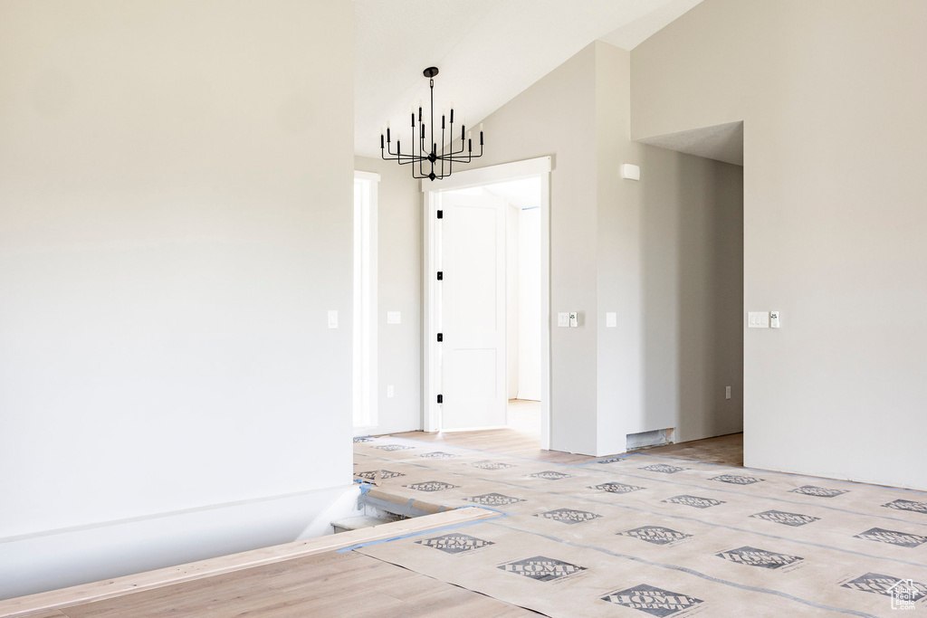 Unfurnished dining area featuring a chandelier and vaulted ceiling