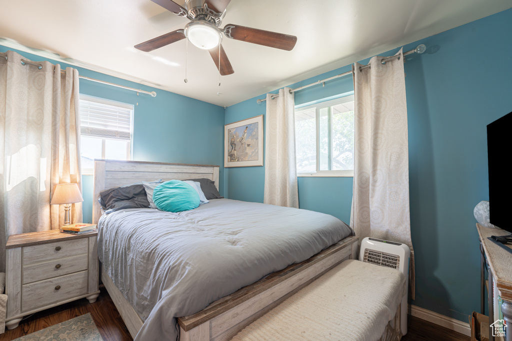Bedroom with wood finished floors, a ceiling fan, and baseboards