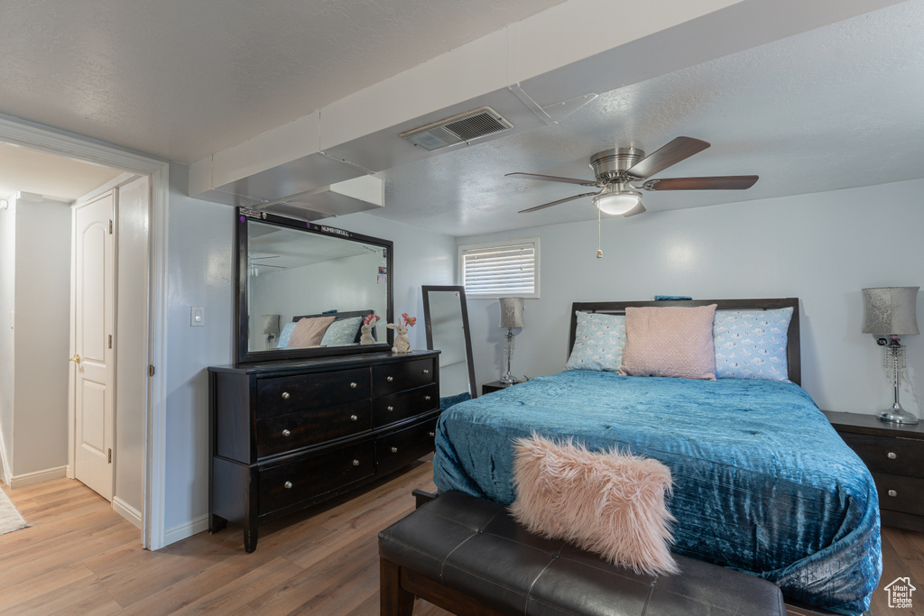 Bedroom featuring wood finished floors, baseboards, and ceiling fan