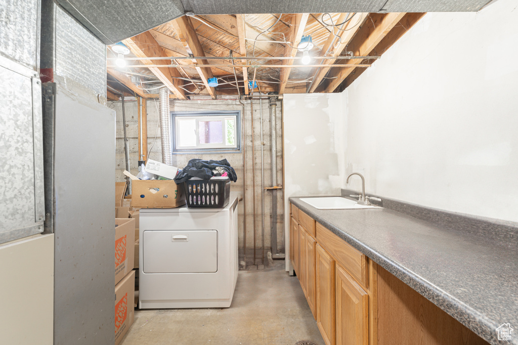 Washroom featuring washer and clothes dryer and cabinet space