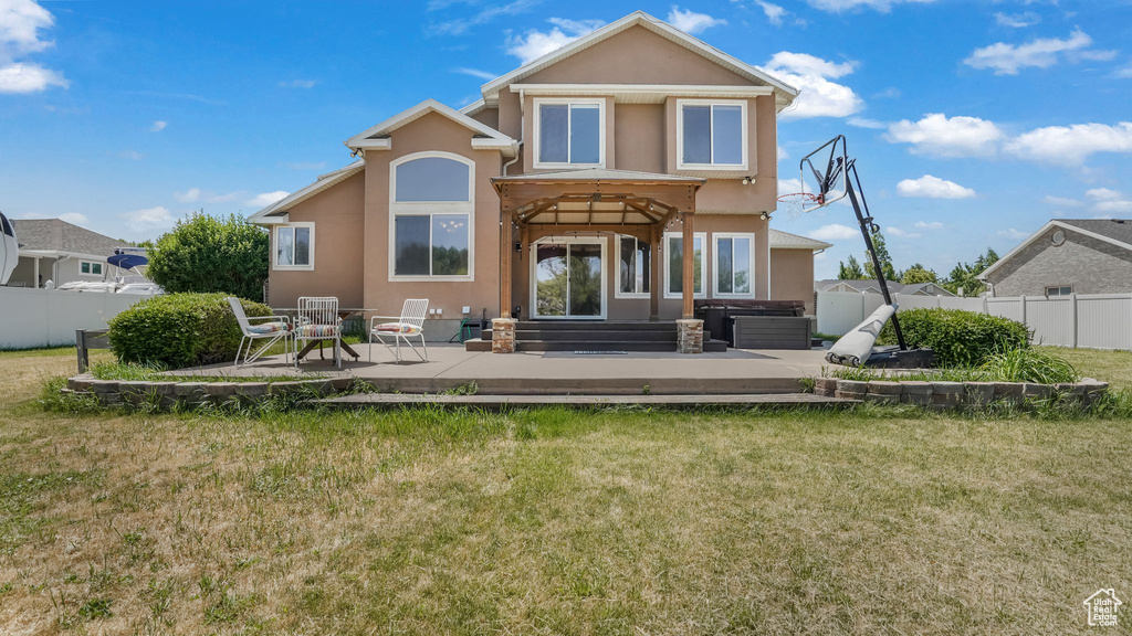 Rear view of house with stucco siding and a patio area
