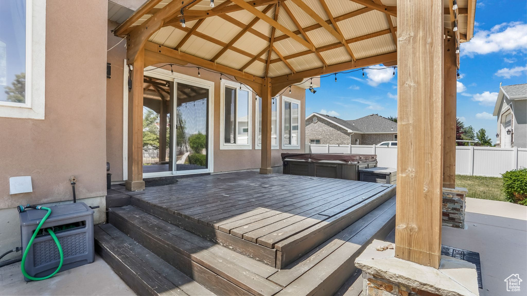 Wooden deck with a hot tub and a gazebo