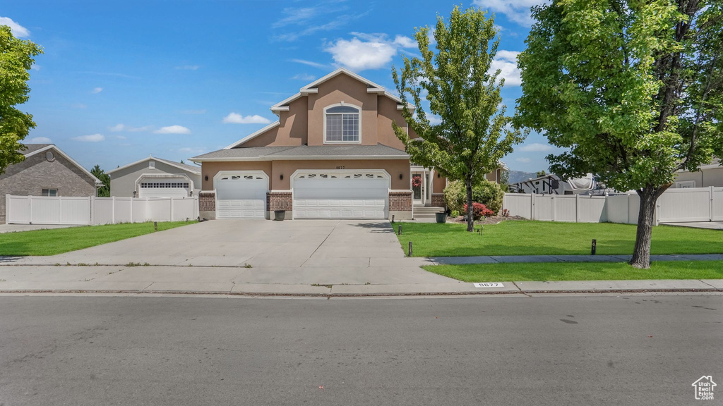 Traditional-style home with brick siding, stucco siding, concrete driveway, and an attached garage