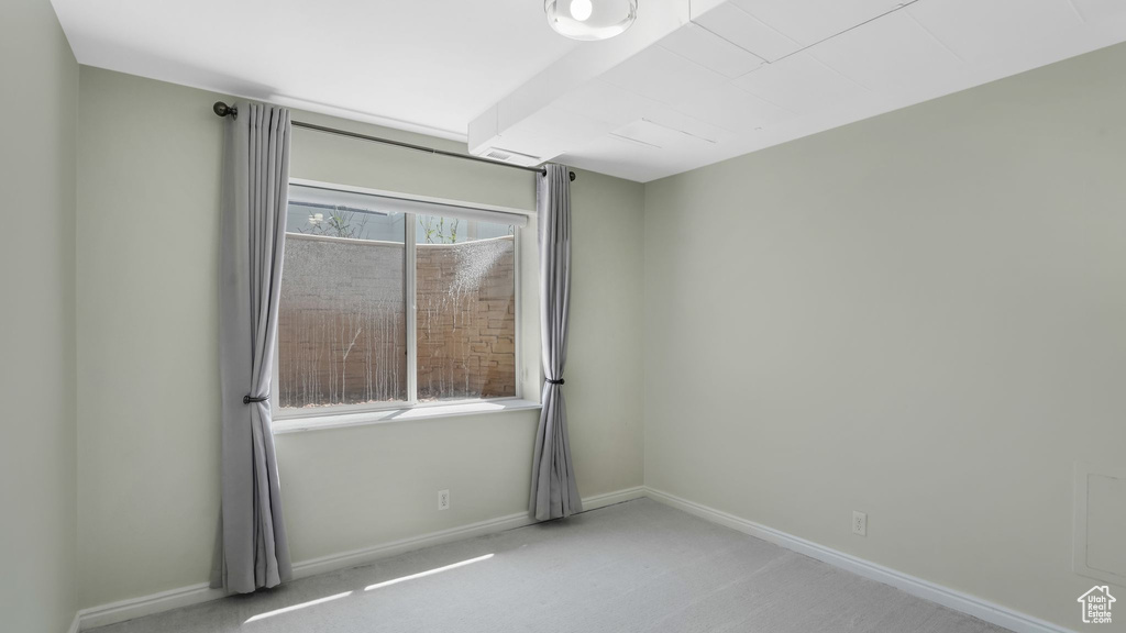 Carpeted empty room featuring baseboards