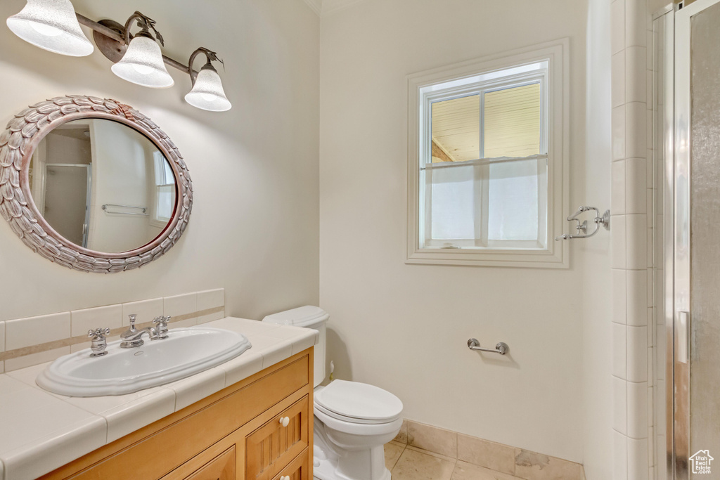 Bathroom featuring vanity, tile patterned flooring, and toilet