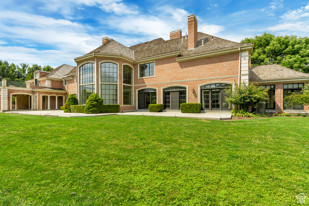 Rear view of house with a garage and a yard