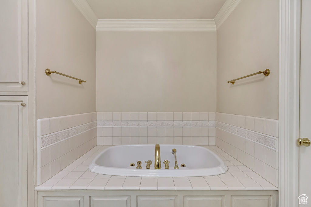Bathroom featuring crown molding and a bath