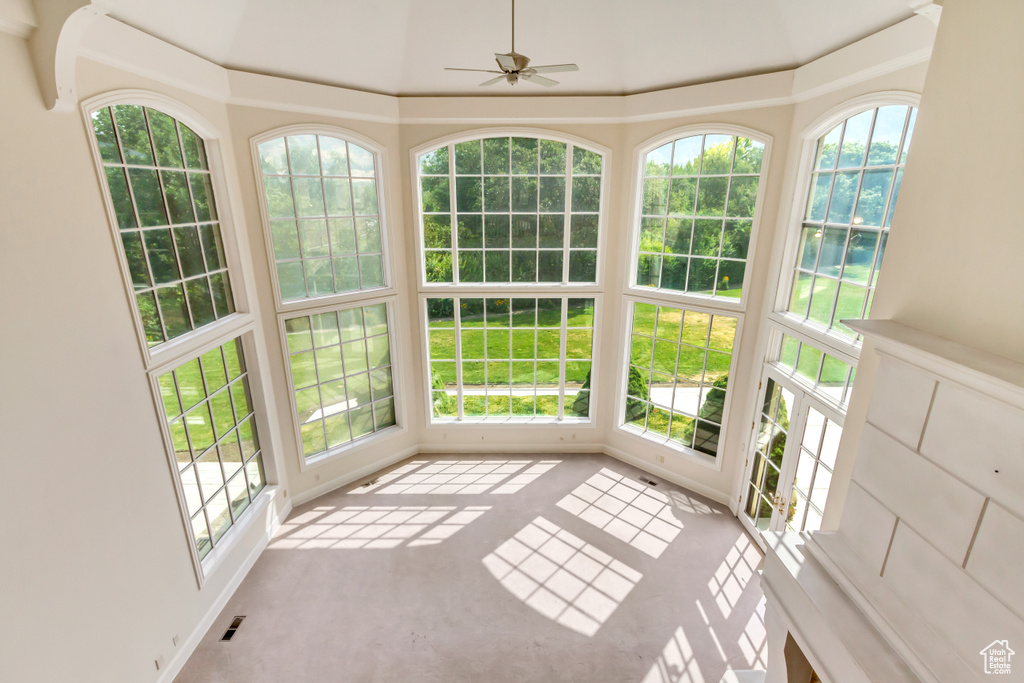 Unfurnished sunroom featuring ceiling fan