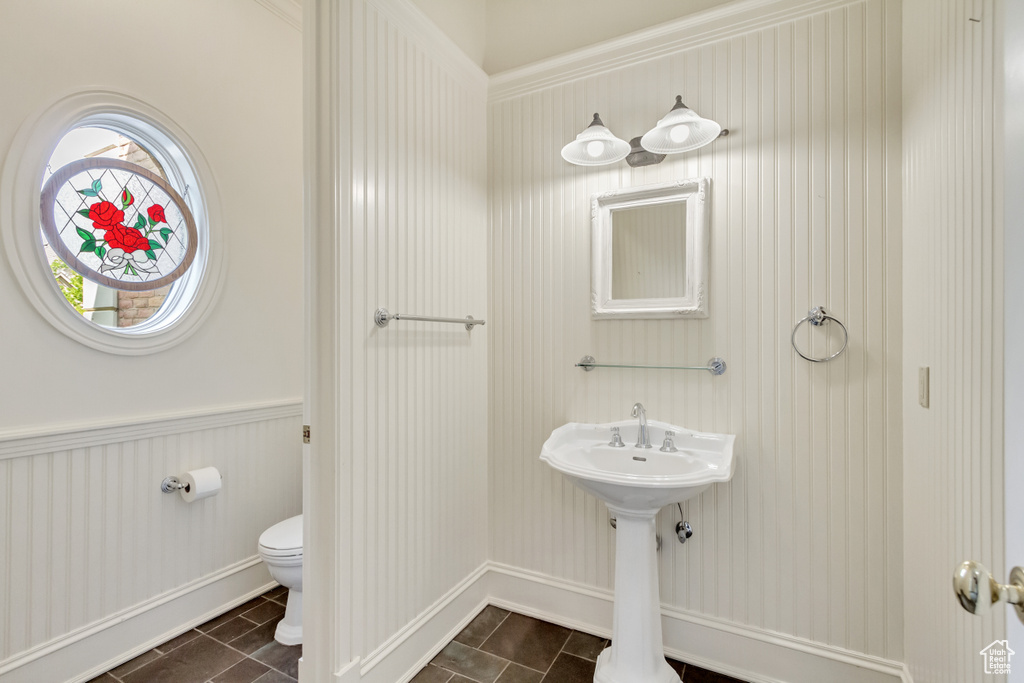 Bathroom with crown molding, toilet, and tile patterned flooring