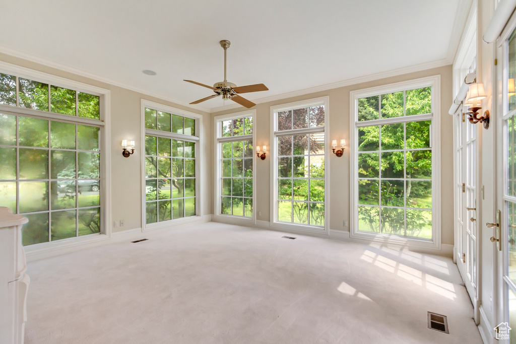 Unfurnished sunroom with ceiling fan and a wealth of natural light