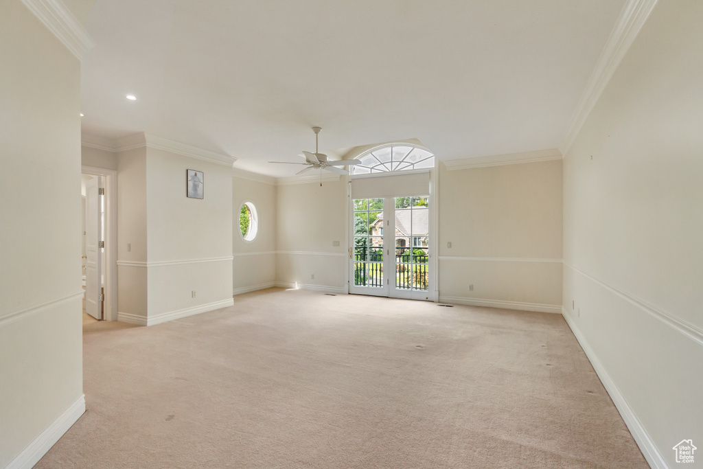 Spare room featuring ceiling fan, french doors, ornamental molding, and light carpet
