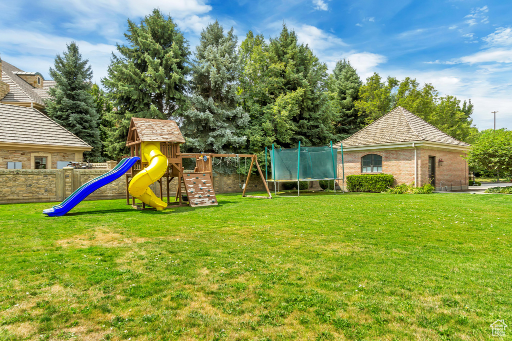 View of yard with a playground and a trampoline