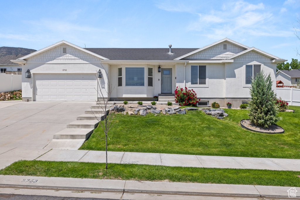Single story home with driveway, a garage, and stucco siding