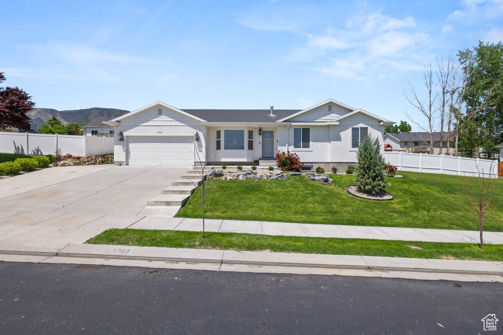 Ranch-style home featuring a garage and driveway