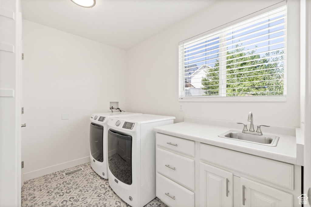 Laundry area with washer and dryer, cabinet space, and baseboards