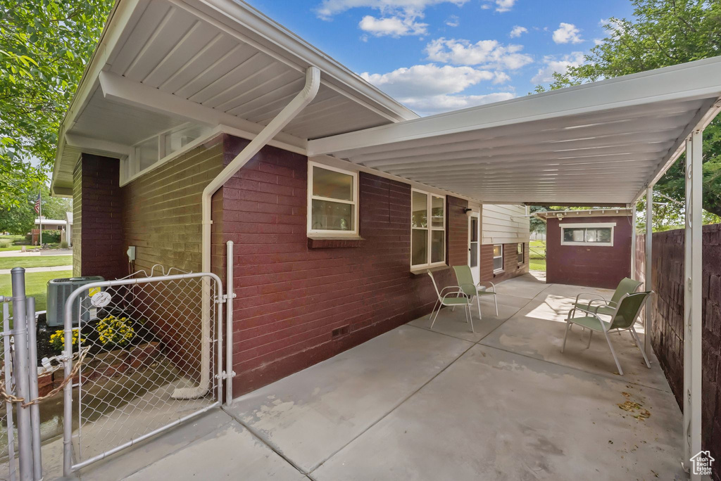 View of property exterior with crawl space, a gate, and brick siding