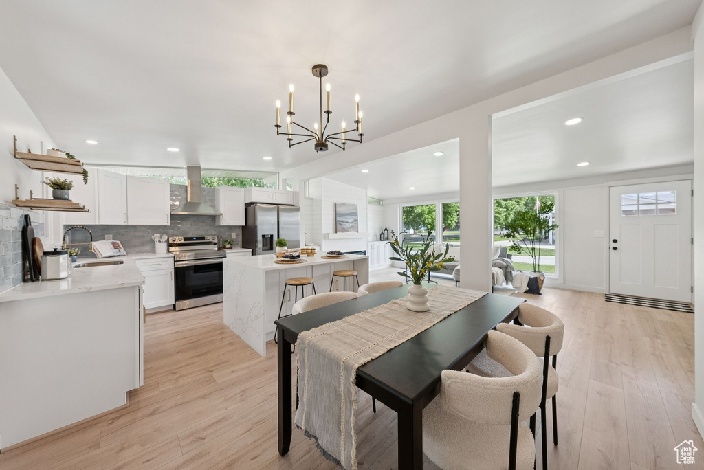 Dining room featuring light wood-type flooring, recessed lighting, and a chandelier