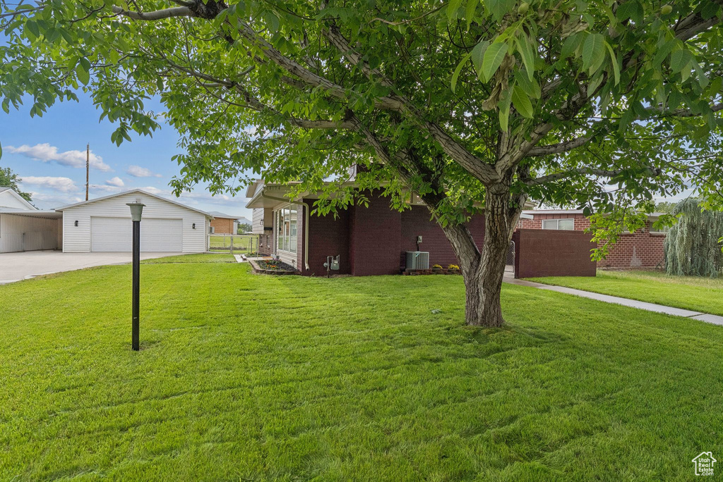 View of yard with an outdoor structure, cooling unit, and driveway